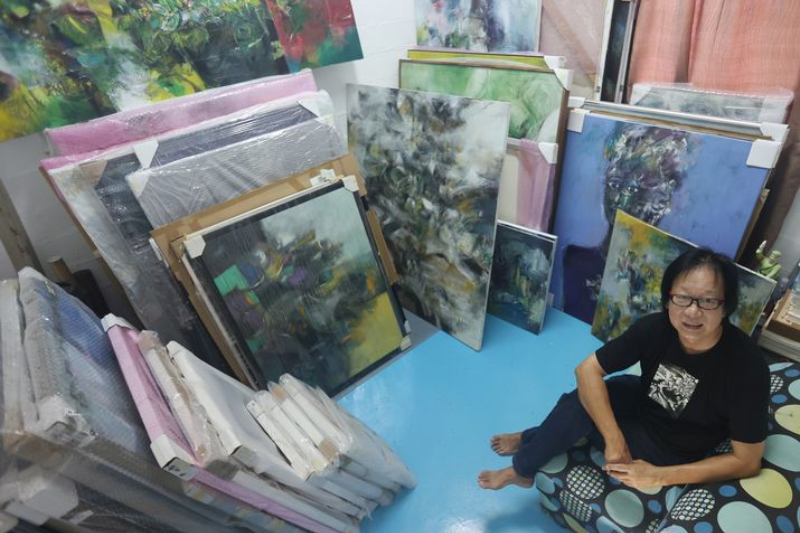 Artist Ng Yak Whee, signed by Prestige Art Gallery, is surrounded by his numerous artworks